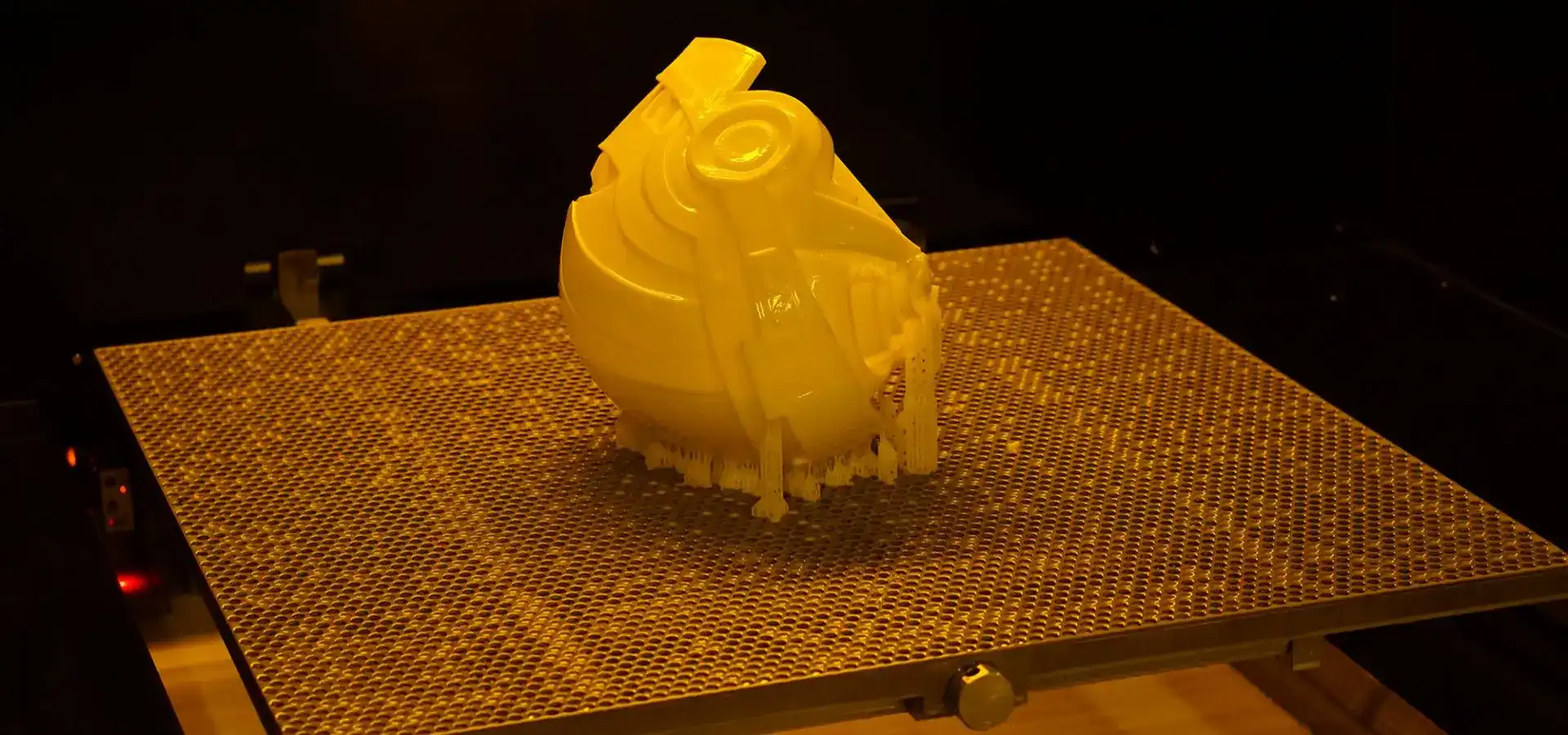 Stereolithography 3D printed helmet prototype on SLA build platform, showcasing high precision and smooth surface finish essential for microfluidic device prototyping Stereolithography 3D printed helmet prototype on SLA build platform, showcasing high precision and smooth surface finish essential for microfluidic device prototyping