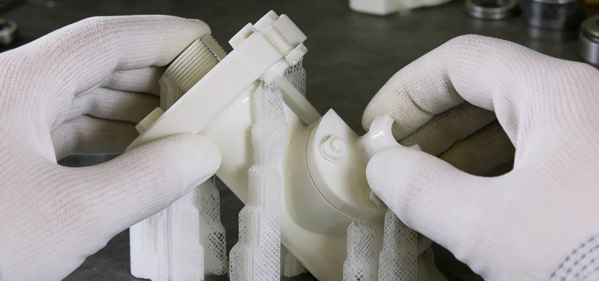 Technician removing support structures from a 3D-printed part during post-processing in a workshop, illustrating a key step in additive manufacturing post-processing workflow Technician removing support structures from a 3D-printed part during post-processing in a workshop, illustrating a key step in additive manufacturing post-processing workflow