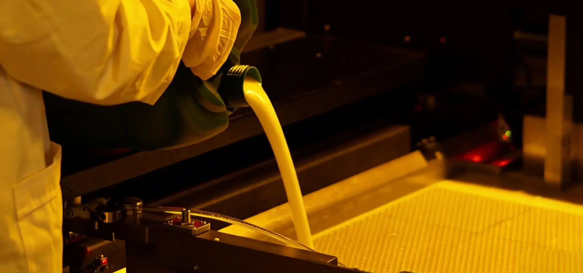 A person pouring photopolymer resin into an SLA 3D printer, preparing for the printing process