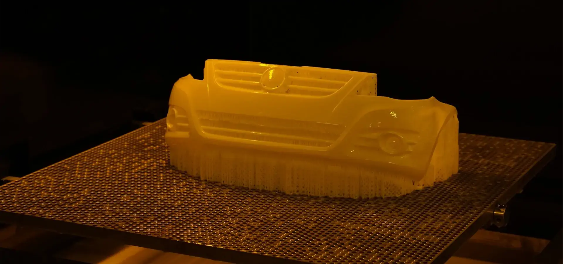 Full-size automotive bumper prototype 3D printed in one piece on a large scale resin 3D printer" style