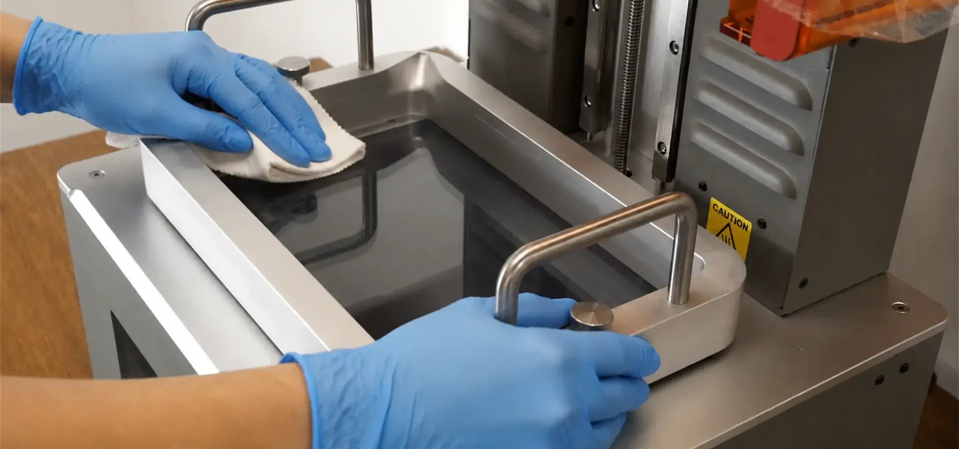 Technician performing preventive maintenance on a resin 3D printing machine